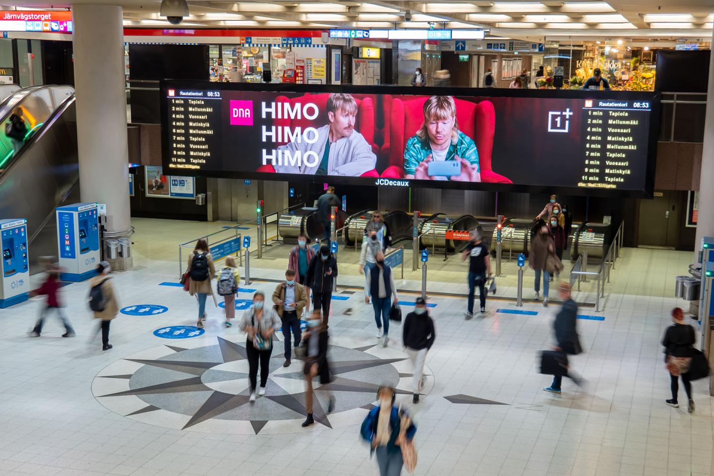 Rautatientorin näytöllä DNAn mainoskampanja.