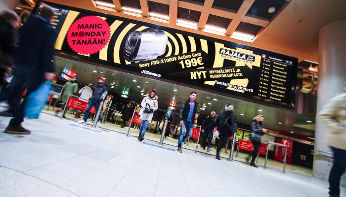 Rajalan mainos Rautatientorin Compass näytöllä.