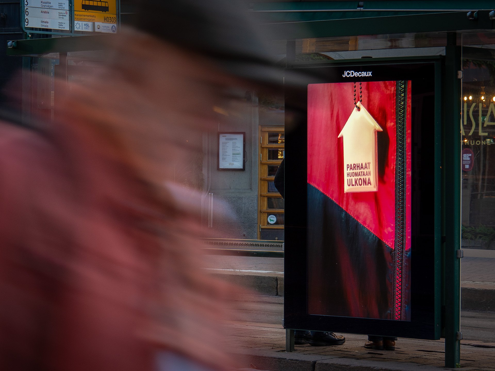 JCDecaux'in oma heijastin aiheinen digitaalinen ulkomainoskampanja ratikkapysäkillä Kaisaniemessä. 