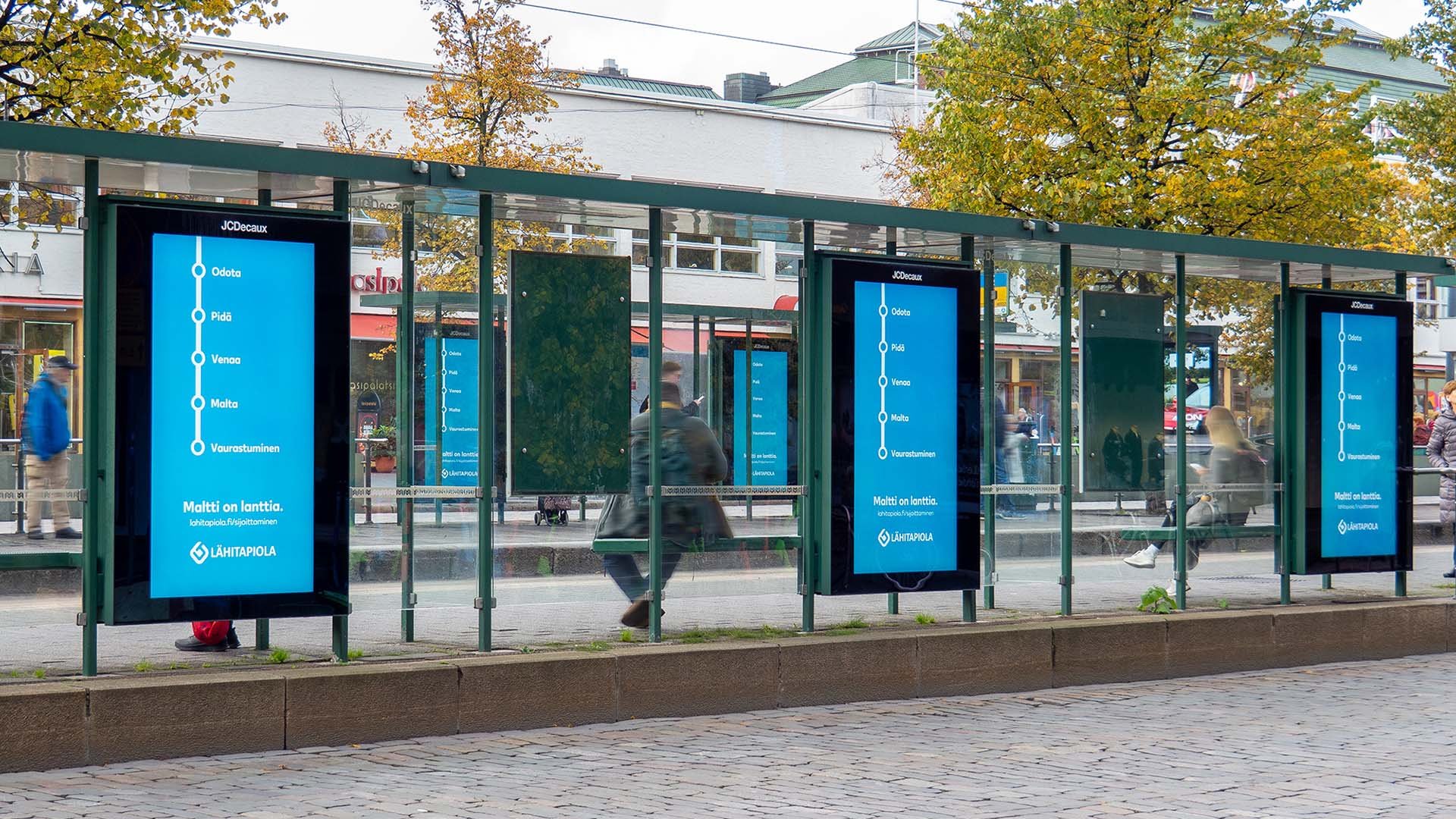 Lähitapiolan digitaalinen ulkomainoskampanja Lasipalatsin ratikkapysäkillä Helsingissä.