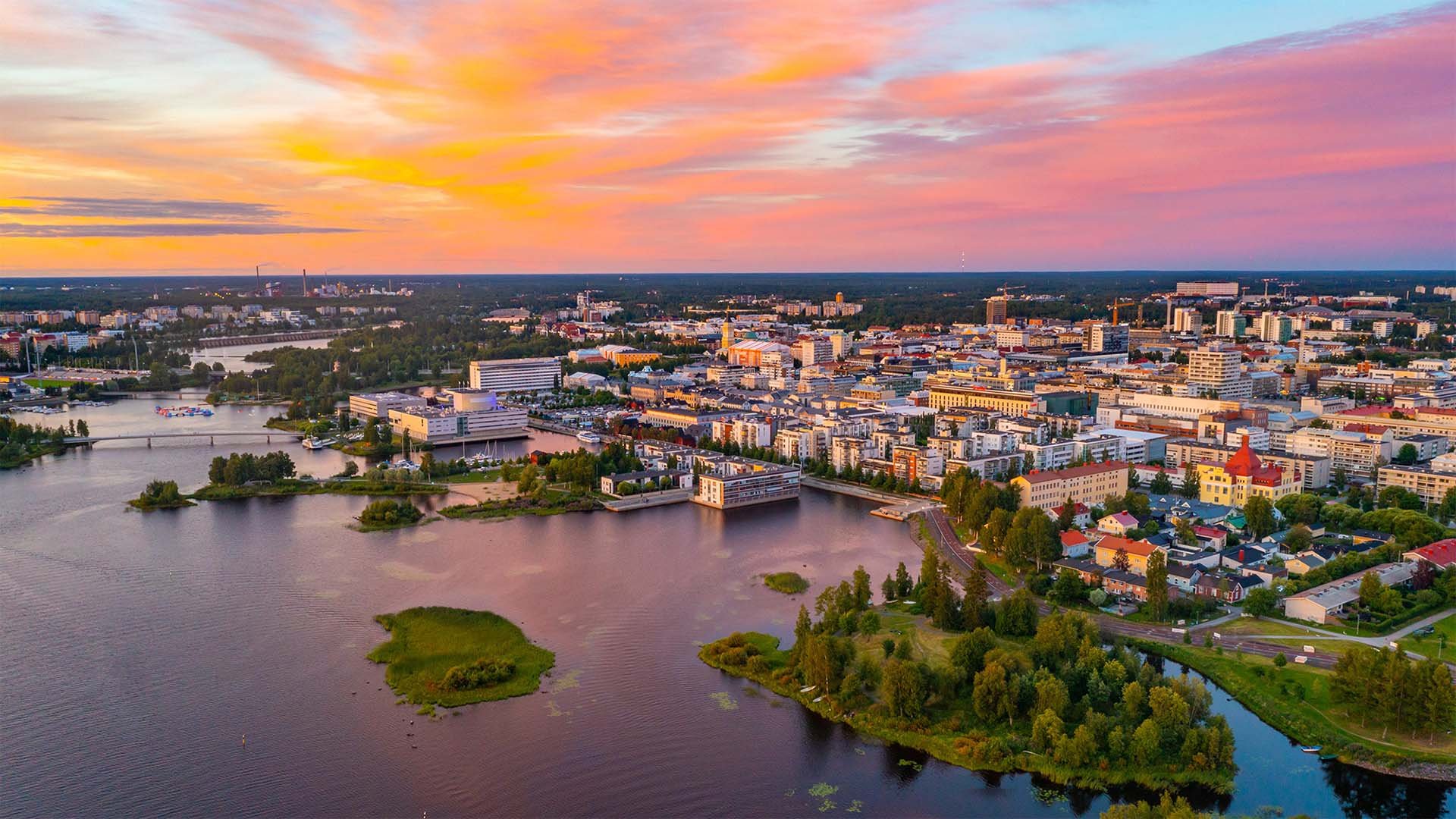 Ilmakuva upeasta auringonlaskusta Oulun kaupungin yllä.