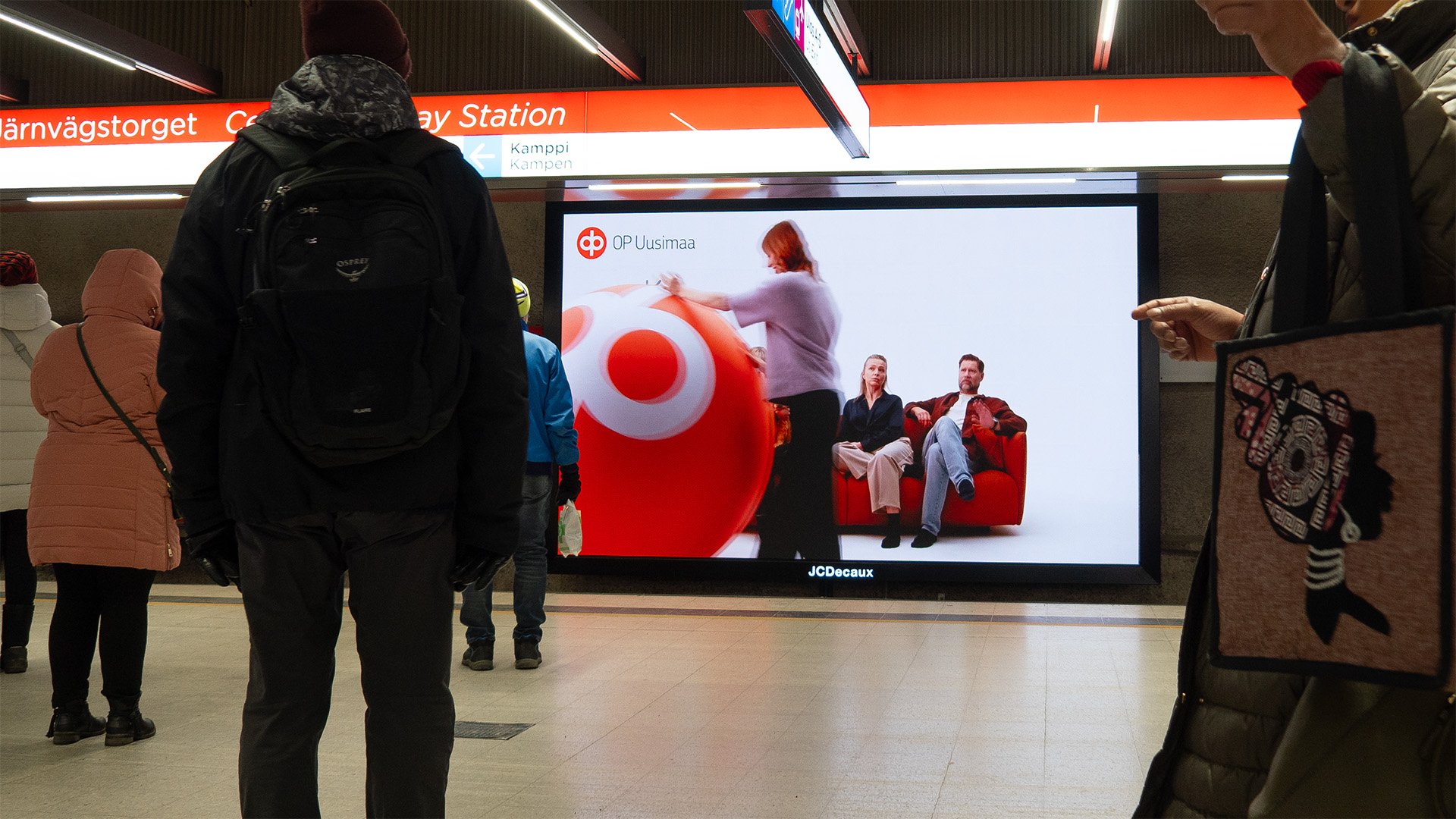 OP Uusimaan digitaalinen ulkomainoskampanja Rautatientorin metroaseman näytöllä.